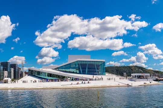 Blick vom Wasser aus auf ein futuristisches Geb&auml;ude in hellgrau in Oslo